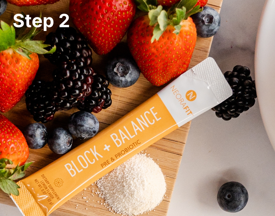 Lifestyle shot of the NeoraFit Block + Balance pre & probiotic sachet on a wooden board surrounded by various berries.